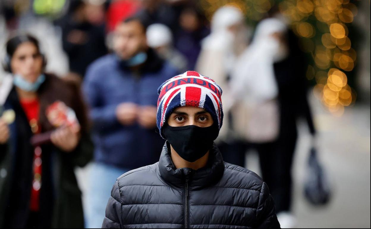 Un joven camina por la calle Oxford, en el centro de Londres, con un gorro con la bandera del Reino Unido.