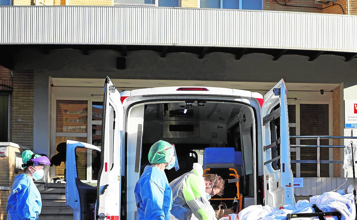 Sanitarios trasladan enfermos al pabellón instalado en la antigua Fe. 