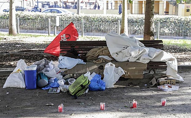 Cuatro velas junto al banco donde dormía el indigente fallecido. 