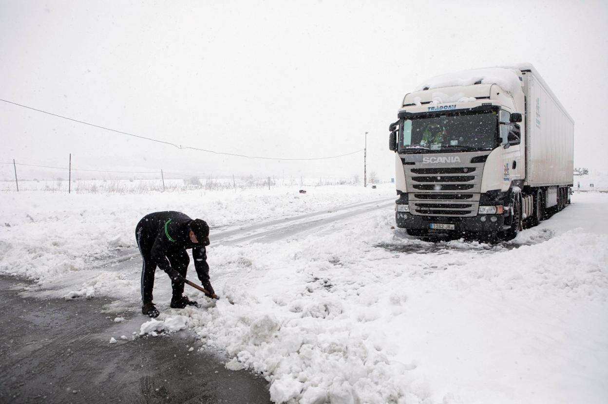 Un camionero intentando limpiar la carretera A-23 para poder acceder a Barracas. efe/ Biel Aliño