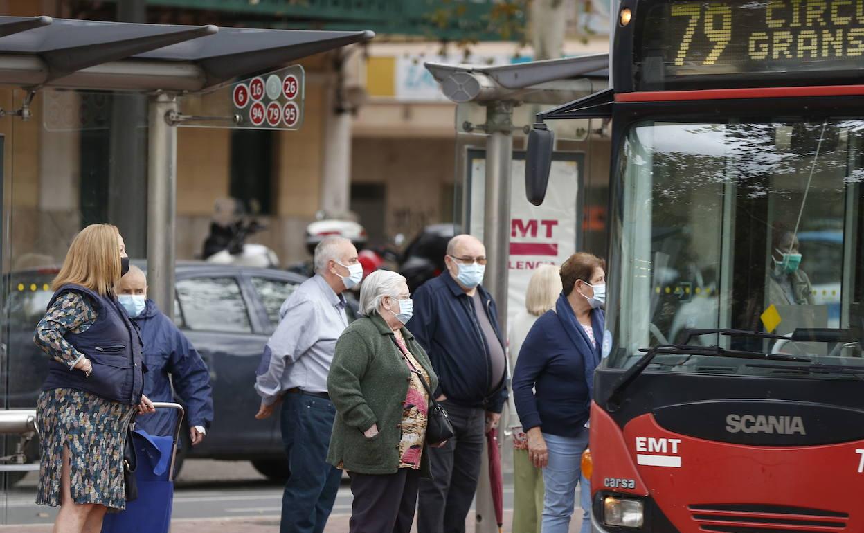 Varios usuarios esperan en una parada de la EMT.