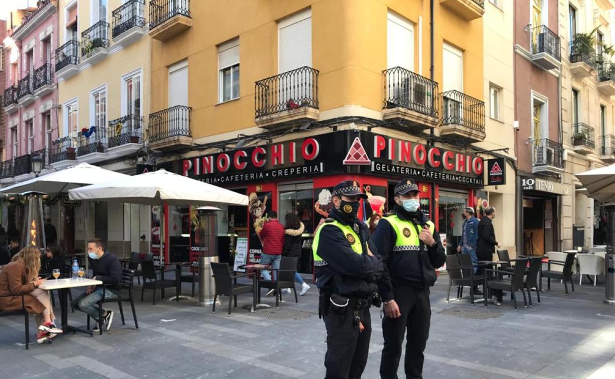 Dos agentes vigilan la calle Castaños de Alicante durante este fin de semana. 