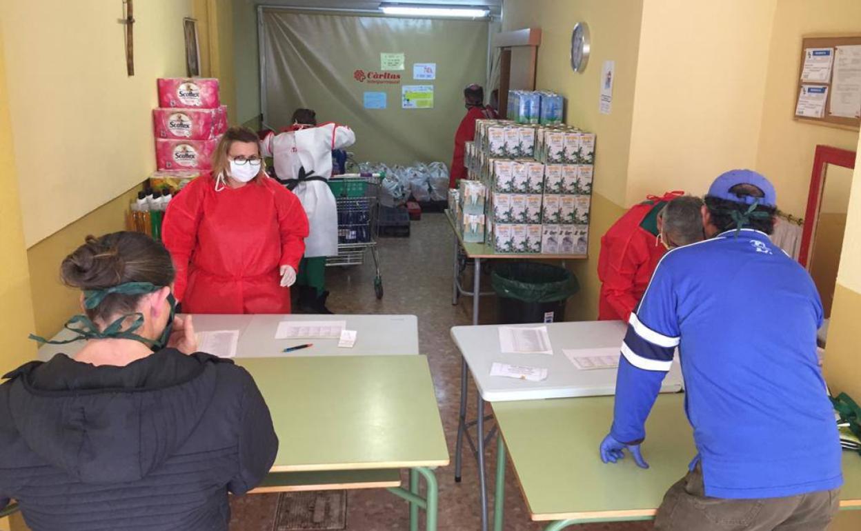 Voluntarios de Cáritas repartiendo productos en el economato. 