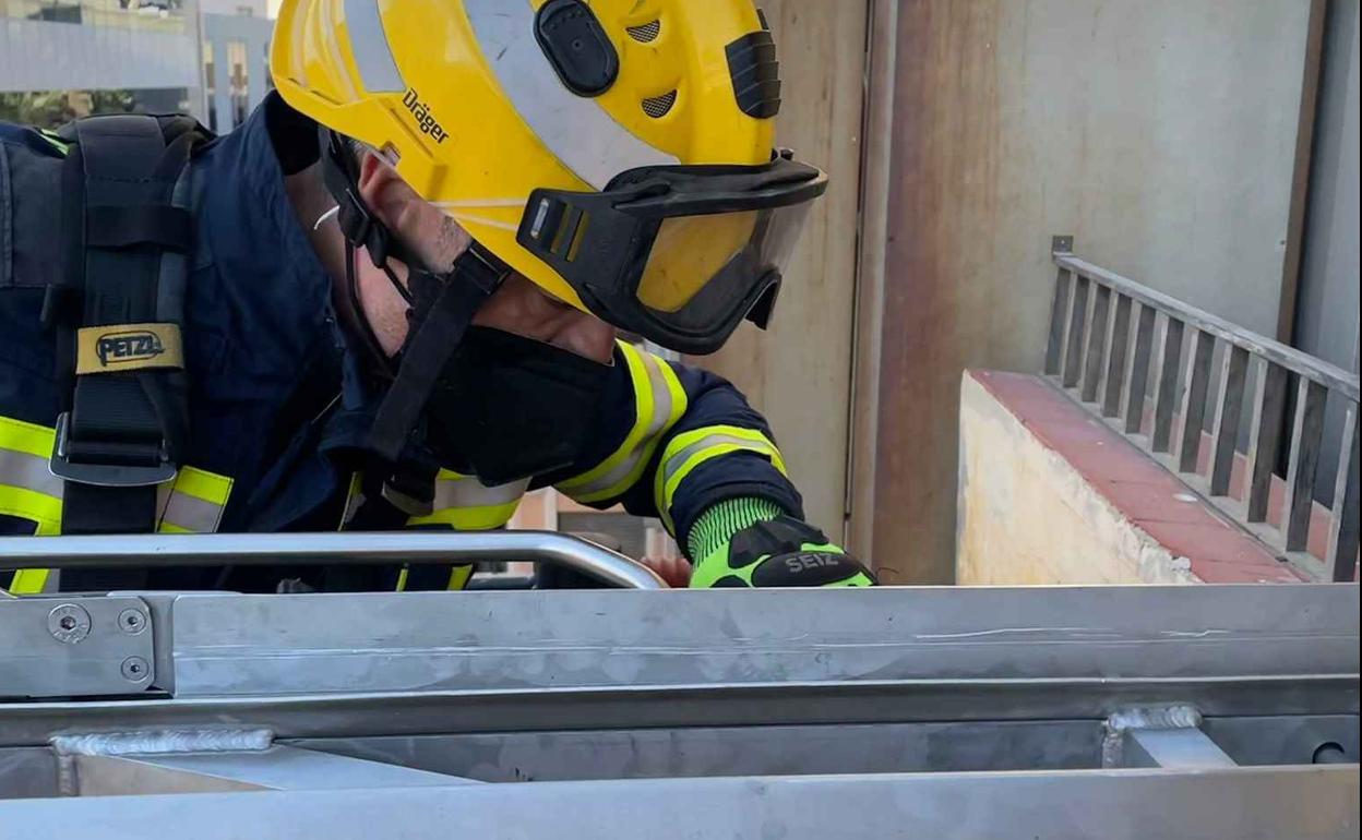 Los bomberos acceden al edificio con el vehículo escalera para rescatar al herido. 