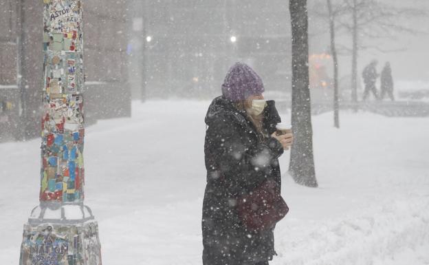 Una mujer camina entre la nieve en Nueva York.