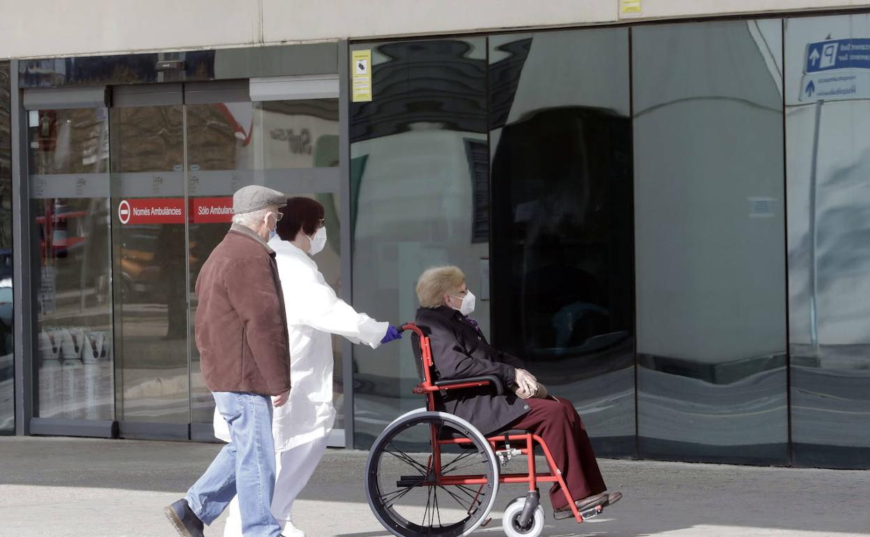 Sanitarios llevan a una paciente al interior de La Fe. 