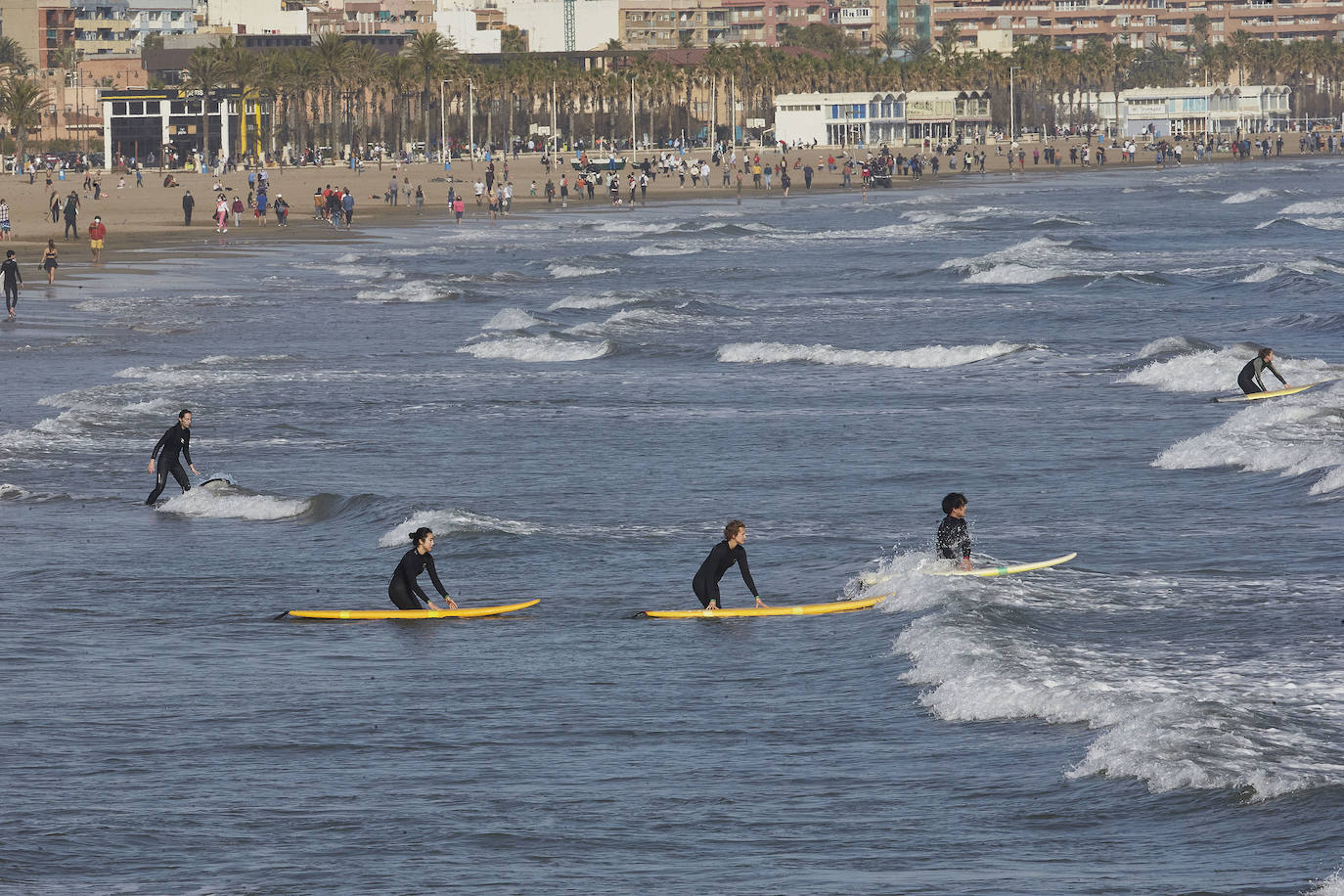 A falta de otras distracciones -los comercios están cerrados y escasean las ofertas de ocio y culturales- los valencianos se han lanzado este fin de semana a los parques, paseos y playas de la ciudad para disfrutar de este fin de semana de restricciones a causa de la pandemia de Covid. Los largos paseos y la práctica de deportes como el running o el surf son ahora las formas preferidas de ocio. 