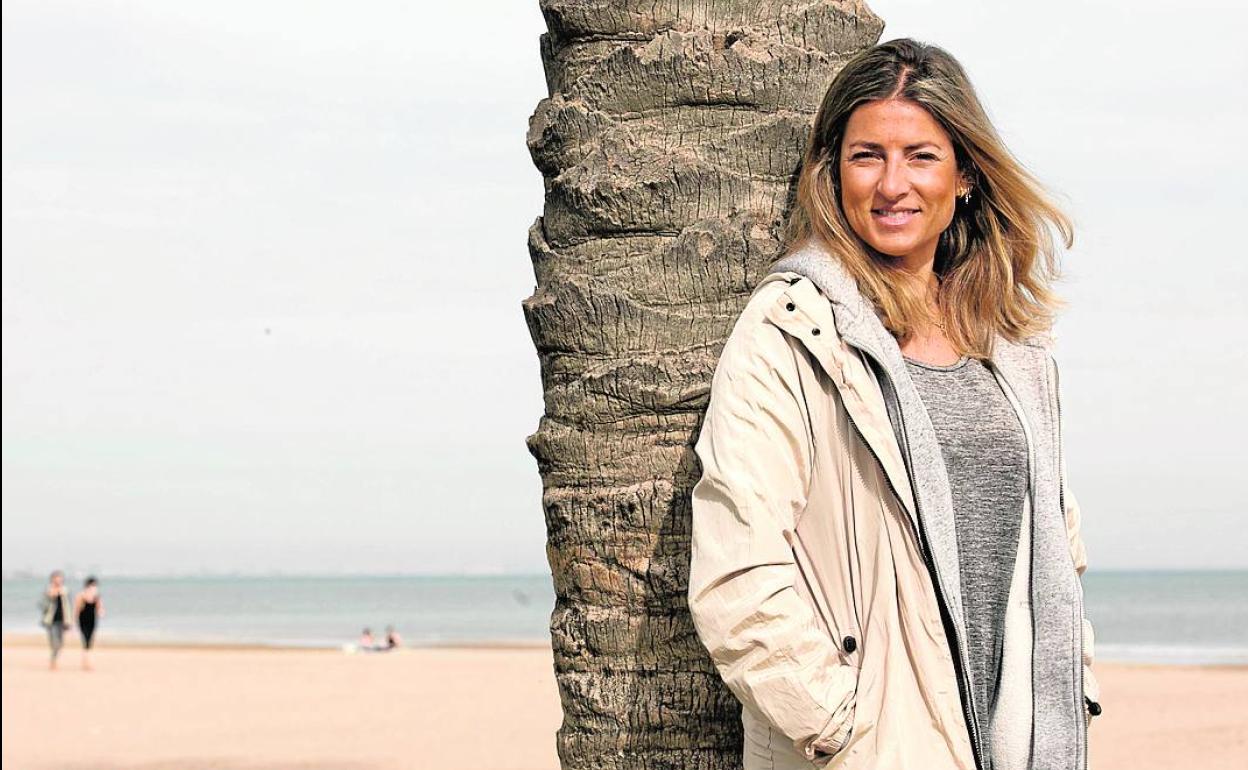 Lorena Oliver, apoyada en una de las palmeras en la playa.