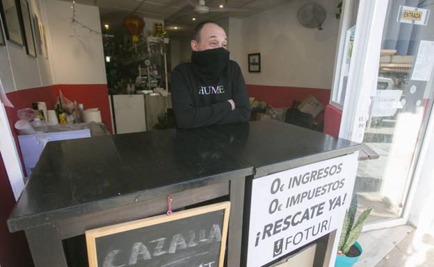 Vicente, con un enfado evidente por la situación, sirve cafés y almuerzos en un bar junto al mercado de Ruzafa.