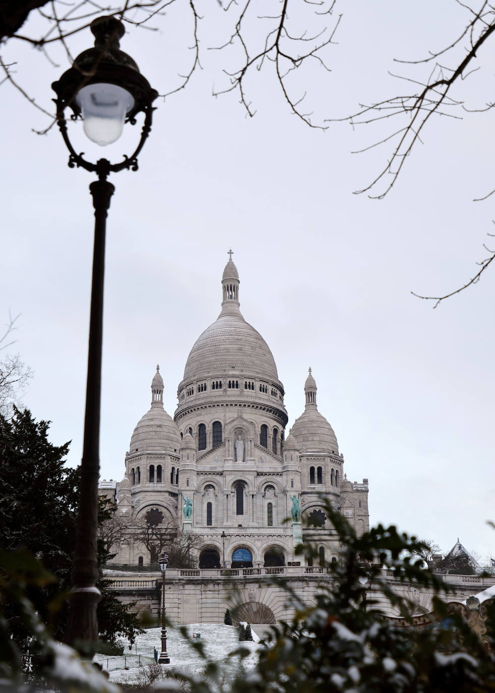 La tormenta Darcy que azota a varios países de Europa provocó que la capital francesa amaneciera con temperaturas bajo cero y con calles e históricos monumentos teñidos de blanco. En la imagen, la colina de Montmartre cerca de la Basílica del Sacré Coeur