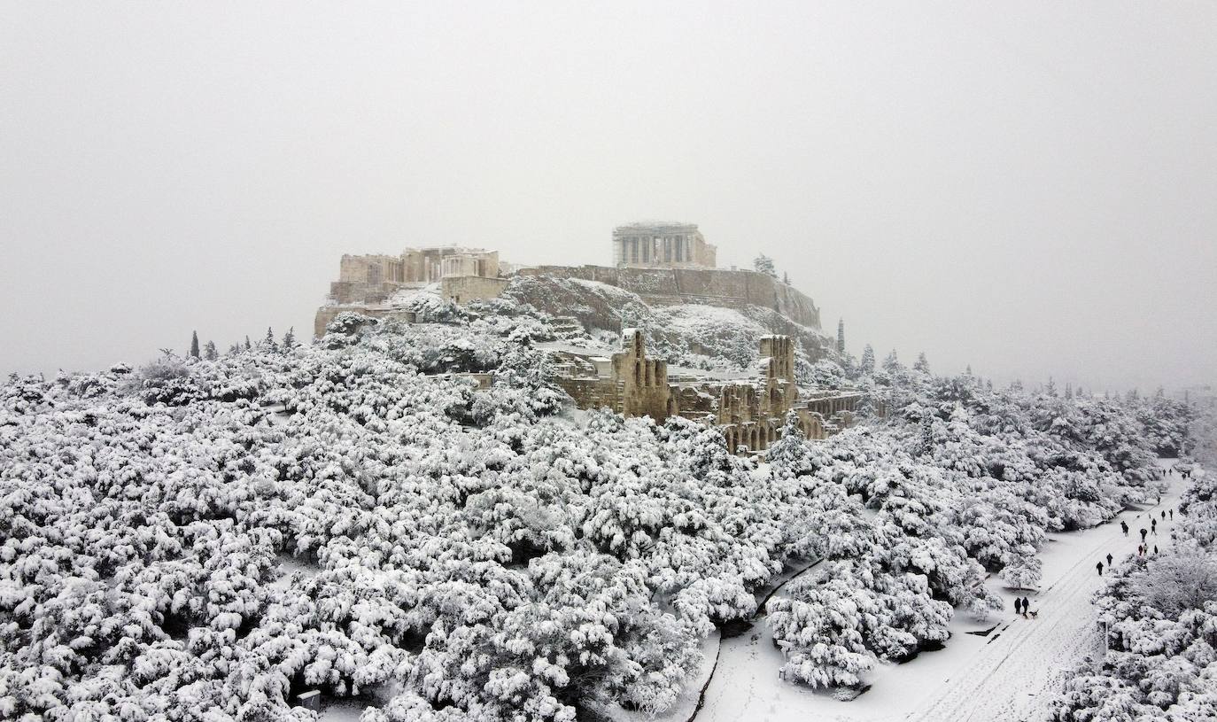 La Acrópolis de Atenas se despertó este martes bajo un manto de nieve al igual que otros monumentos de la antigüedad en la capital griega, ofreciendo un espectáculo excepcional en medio de la ola de frío 'Medea' que afecta al país. El Partenón, el célebre templo del siglo V antes de nuestra era, en lo alto del peñasco en el centro histórico, apenas podía verse a raíz de la nieve que cayó en la noche.