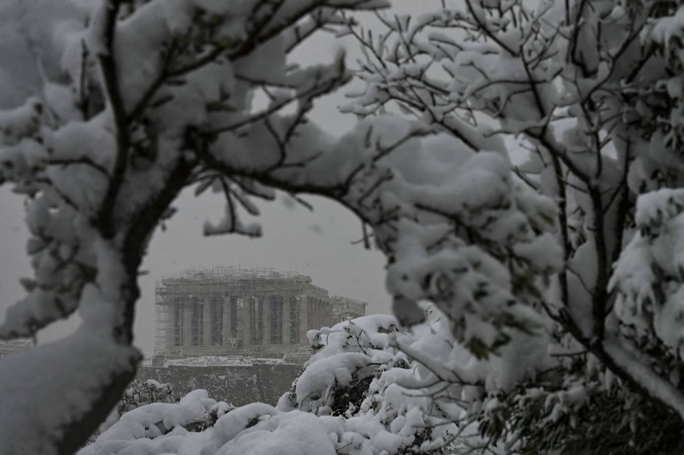 La Acrópolis de Atenas se despertó este martes bajo un manto de nieve al igual que otros monumentos de la antigüedad en la capital griega, ofreciendo un espectáculo excepcional en medio de la ola de frío 'Medea' que afecta al país. El Partenón, el célebre templo del siglo V antes de nuestra era, en lo alto del peñasco en el centro histórico, apenas podía verse a raíz de la nieve que cayó en la noche.