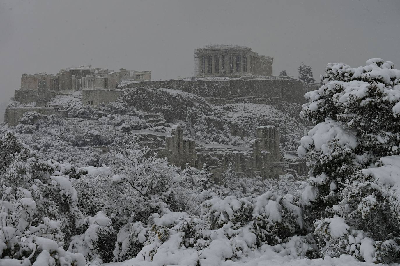 La Acrópolis de Atenas se despertó este martes bajo un manto de nieve al igual que otros monumentos de la antigüedad en la capital griega, ofreciendo un espectáculo excepcional en medio de la ola de frío 'Medea' que afecta al país. El Partenón, el célebre templo del siglo V antes de nuestra era, en lo alto del peñasco en el centro histórico, apenas podía verse a raíz de la nieve que cayó en la noche.