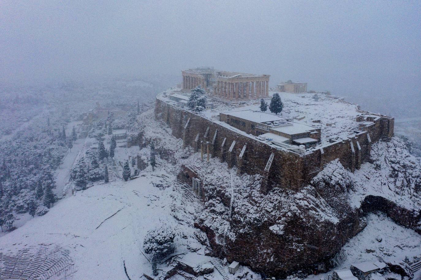 La Acrópolis de Atenas se despertó este martes bajo un manto de nieve al igual que otros monumentos de la antigüedad en la capital griega, ofreciendo un espectáculo excepcional en medio de la ola de frío 'Medea' que afecta al país. El Partenón, el célebre templo del siglo V antes de nuestra era, en lo alto del peñasco en el centro histórico, apenas podía verse a raíz de la nieve que cayó en la noche.