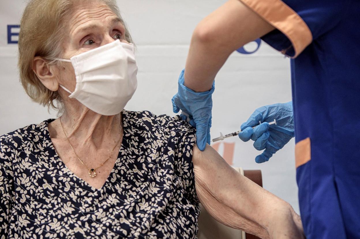 Una mujer que vive en una residencia de Alboraya recibe la vacuna de Pfizer. EFE/Biel Aliño