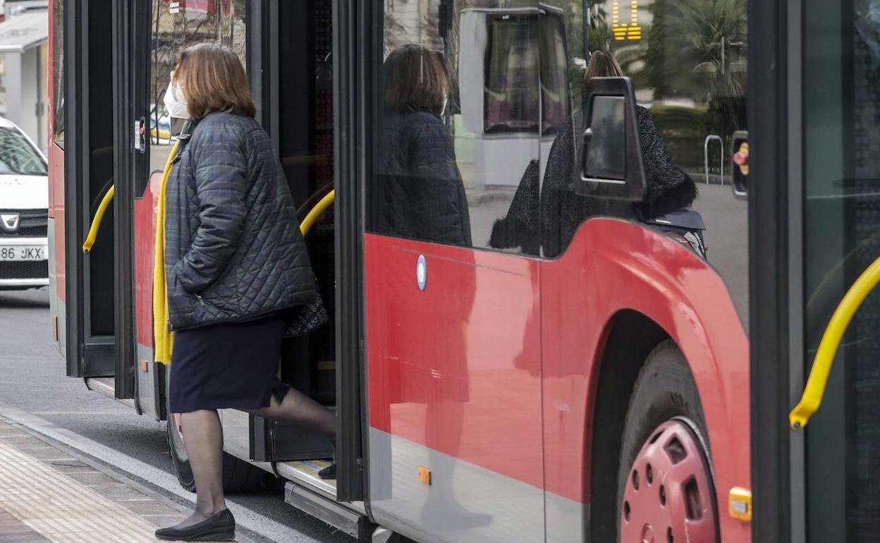 Una mujer baja de un autobús de la EMT.