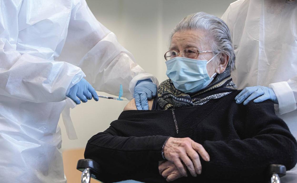 Una anciana se vacuna en una residencia. 