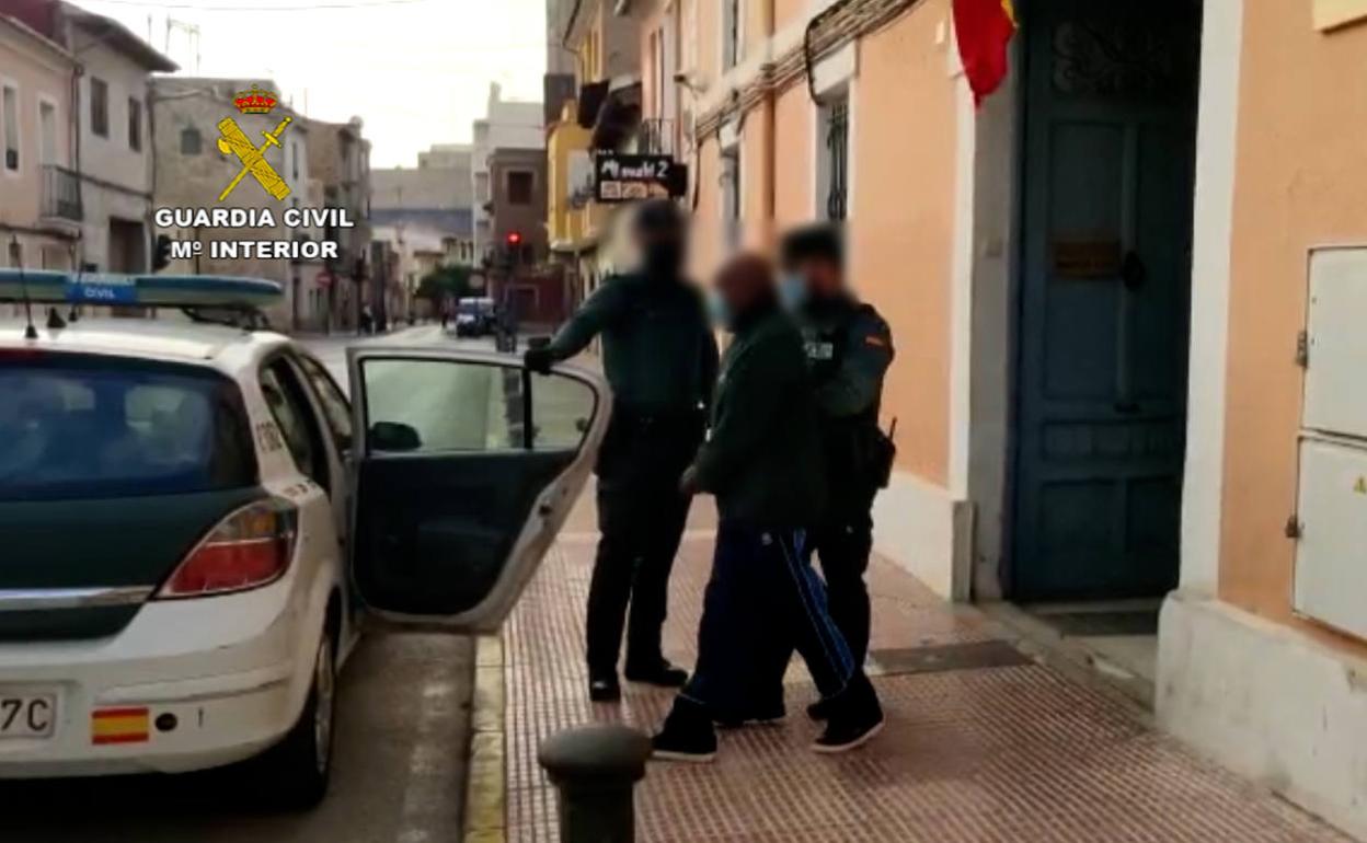 Los agentes trasladan a uno de los dos detenidos. 