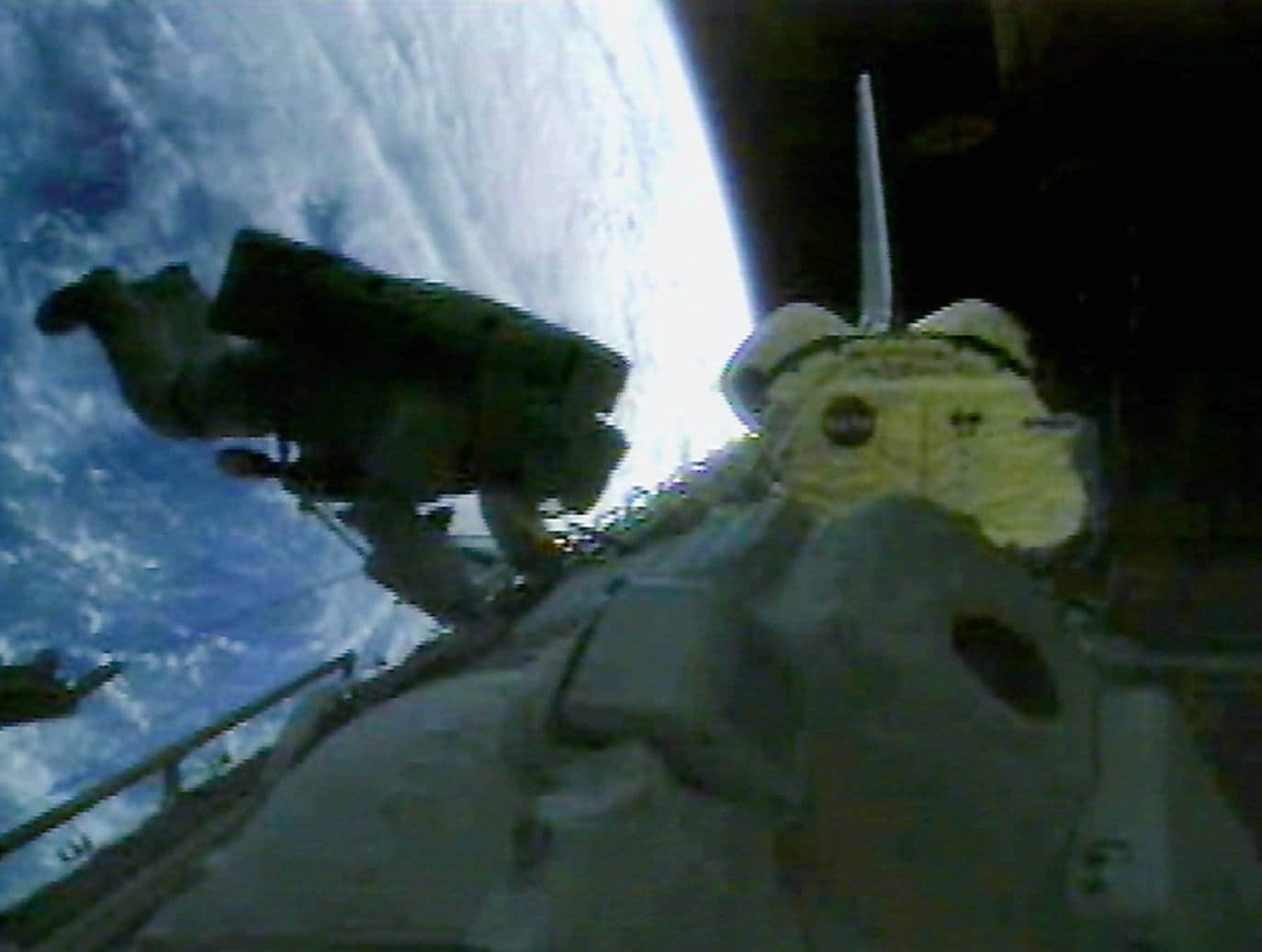 Los cosmonautas Vladimir Titov (d) y Scott Parazynski trabajando en el exterior del transbordador Atlantis.
