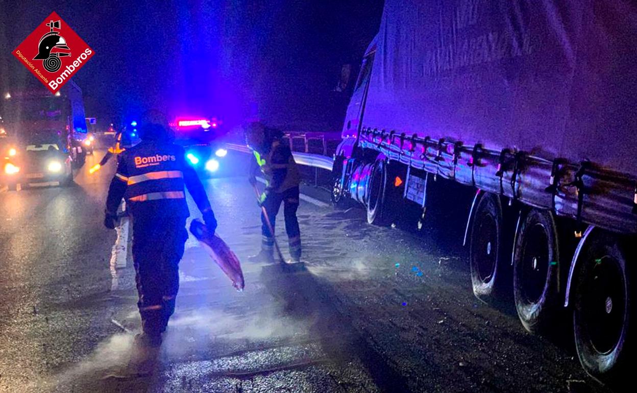 Los bomberos limpian y echan arena para retirar los restos de combustible del asfalto. 