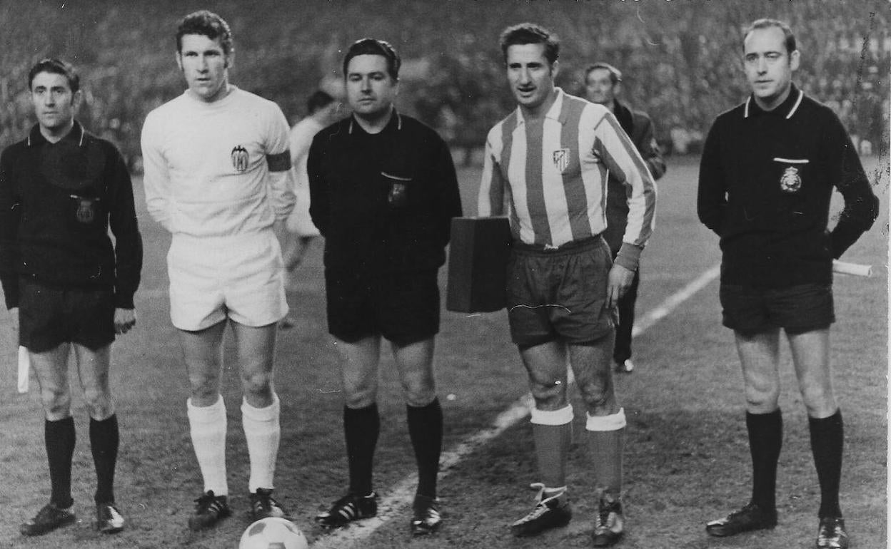 Paquito y Calleja, capitanes del Valencia y del Atlético, antes con al árbitro Medina Iglesias y sus auxiliares.