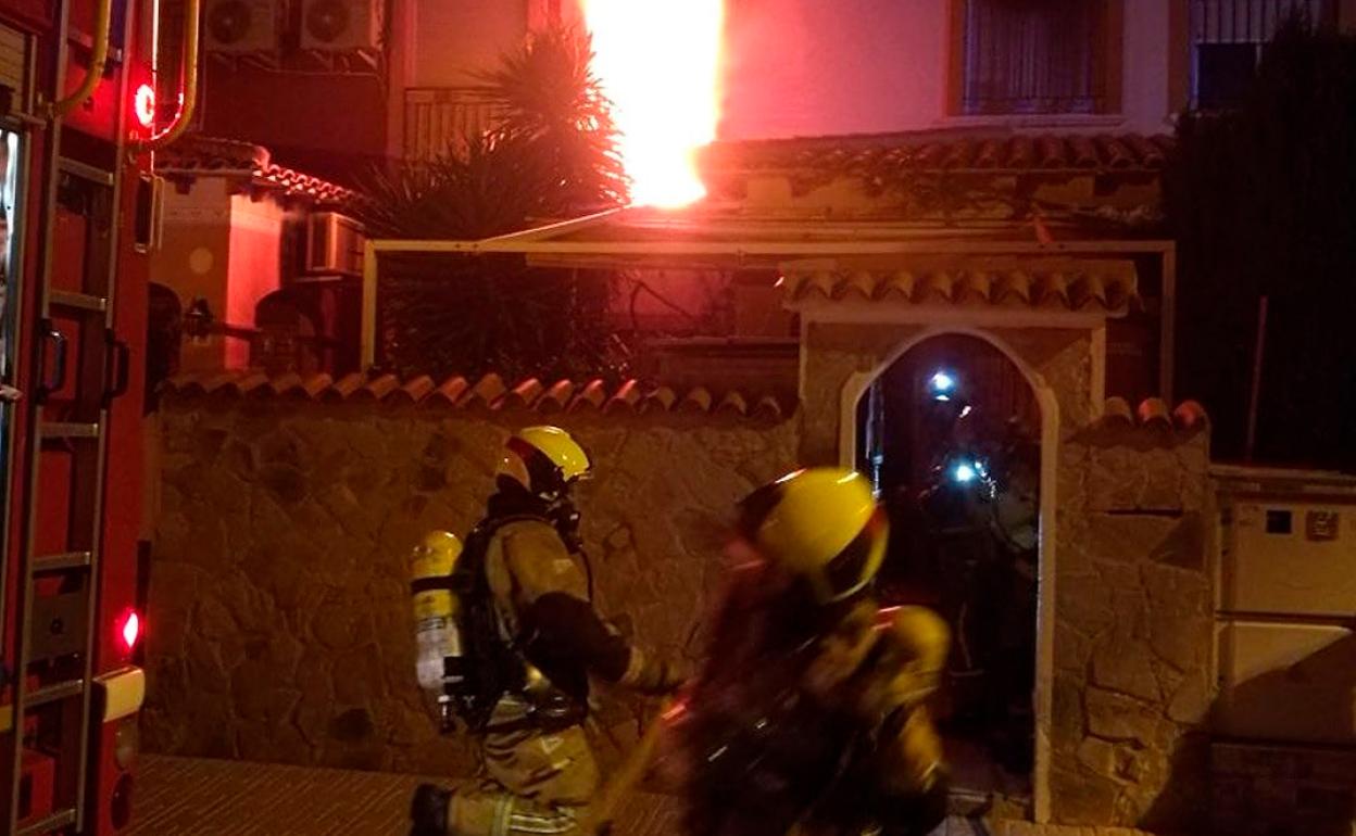 Los bomberos tratan de sofocar las llamas en la vivienda de Torrevieja. 