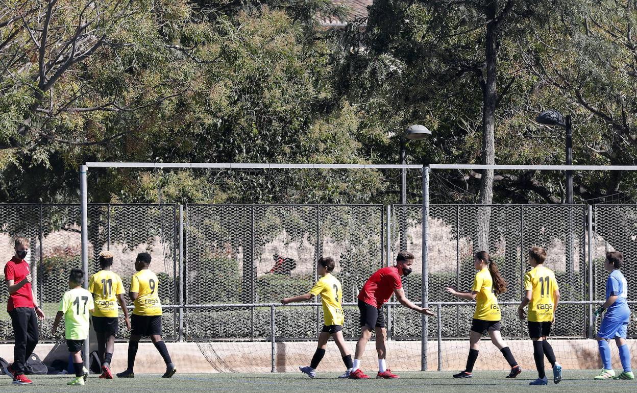 Un equipo de fútbol base se retira tras disputar un partido. 