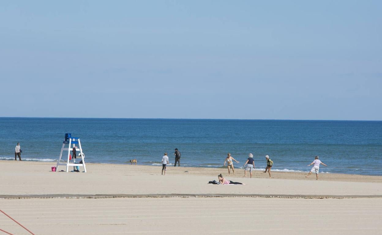 Algunos bañistas disfrutando esta mañana del sol en la playa Nord de Gandia. 