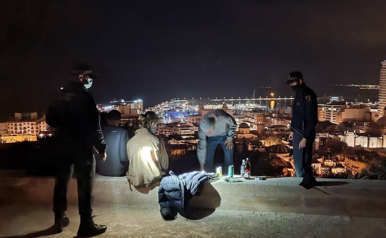 Varios jóvenes, sorprendidos de botellón y disfrutando de buenas vistas en la noche del viernes en Alicante. 