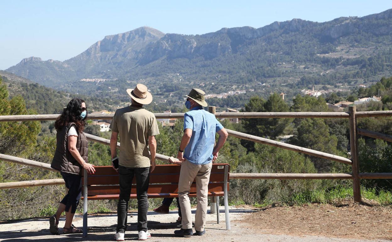 Unos turistas contemplan desde un mirador las espectaculares vistas de la Vall de Gallinera y las montañas que rodean el municipio. 