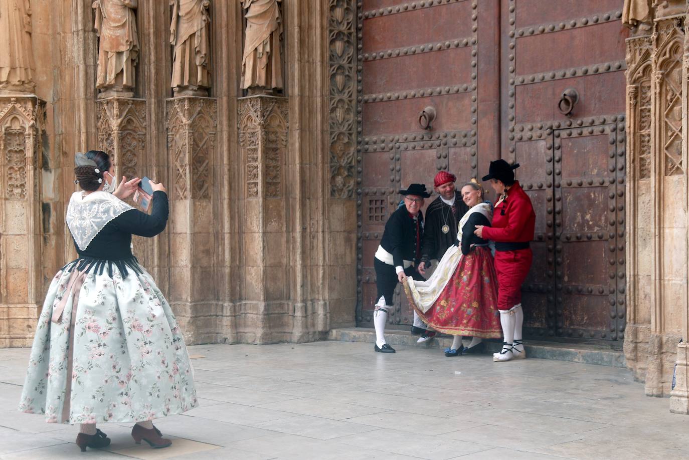 Decenas de personas acuden a la misa de la Catedral y también vestidas de fallera a la Basílica de la Virgen