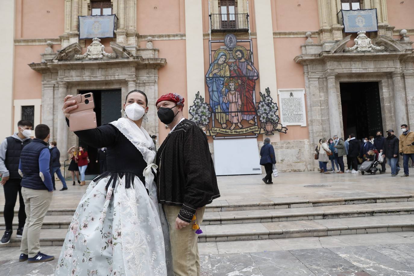 Decenas de personas acuden a la misa de la Catedral y también vestidas de fallera a la Basílica de la Virgen