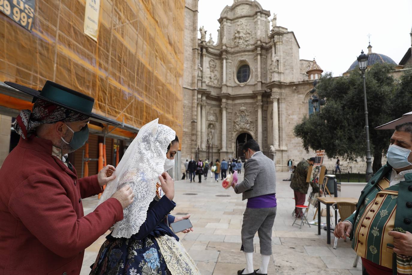 Decenas de personas acuden a la misa de la Catedral y también vestidas de fallera a la Basílica de la Virgen