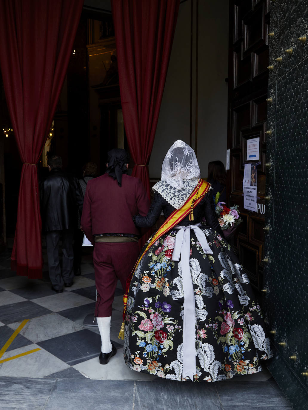 Decenas de personas acuden a la misa de la Catedral y también vestidas de fallera a la Basílica de la Virgen