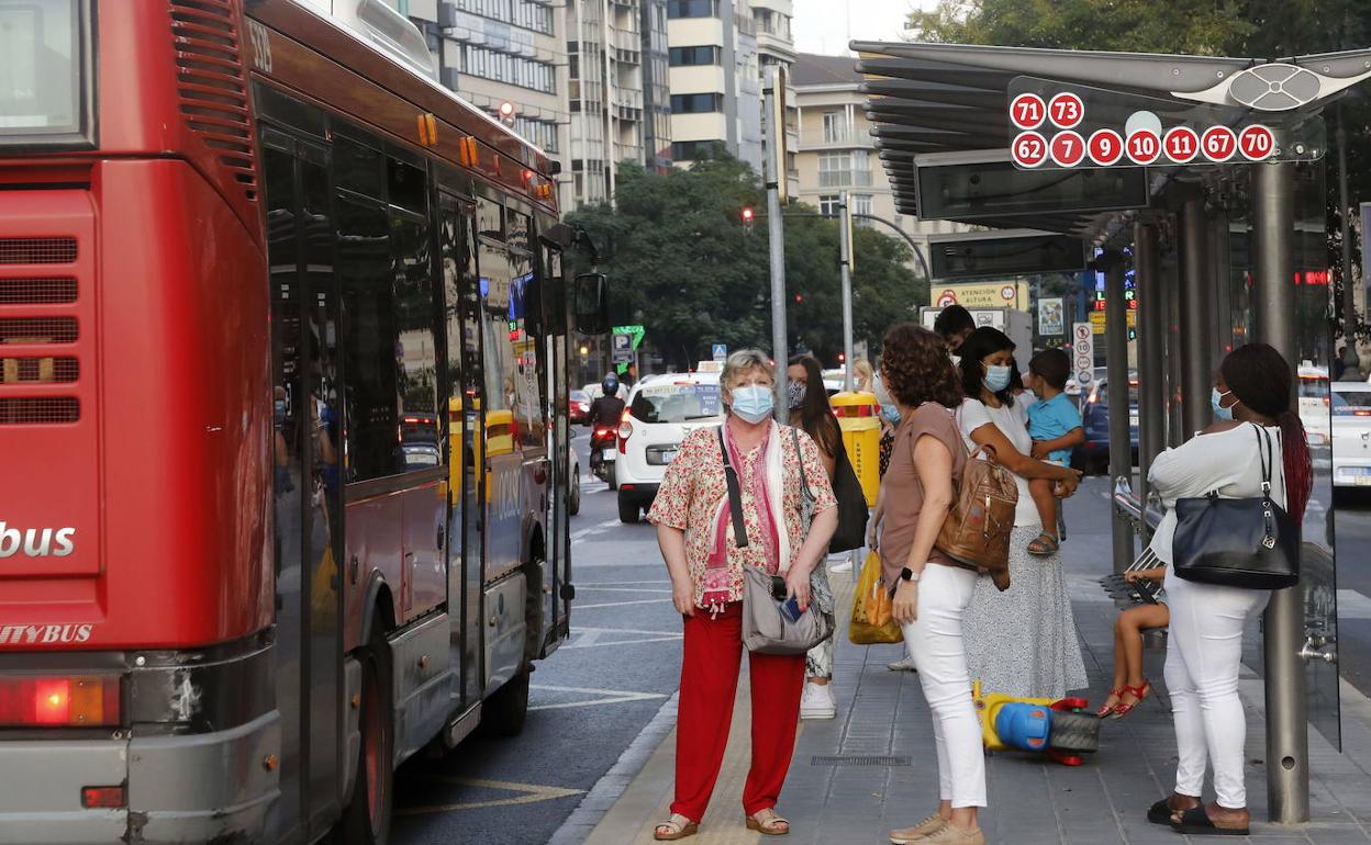 Usuarios de la EMT esperan a un autobús en una parada del centro. 