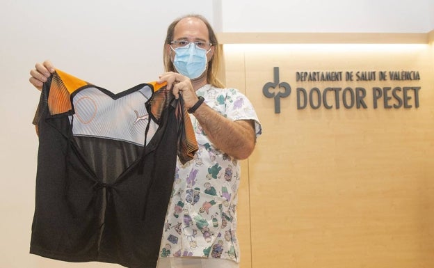 Un sanitario posa con una camiseta del Valencia convertida en bata para los niños hospitalizados. 