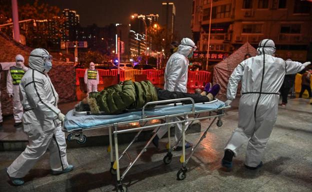 Sanitarios trasladan a una víctima del Covid en Wuhan