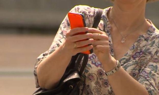 Una mujer consulta su teléfono móvil