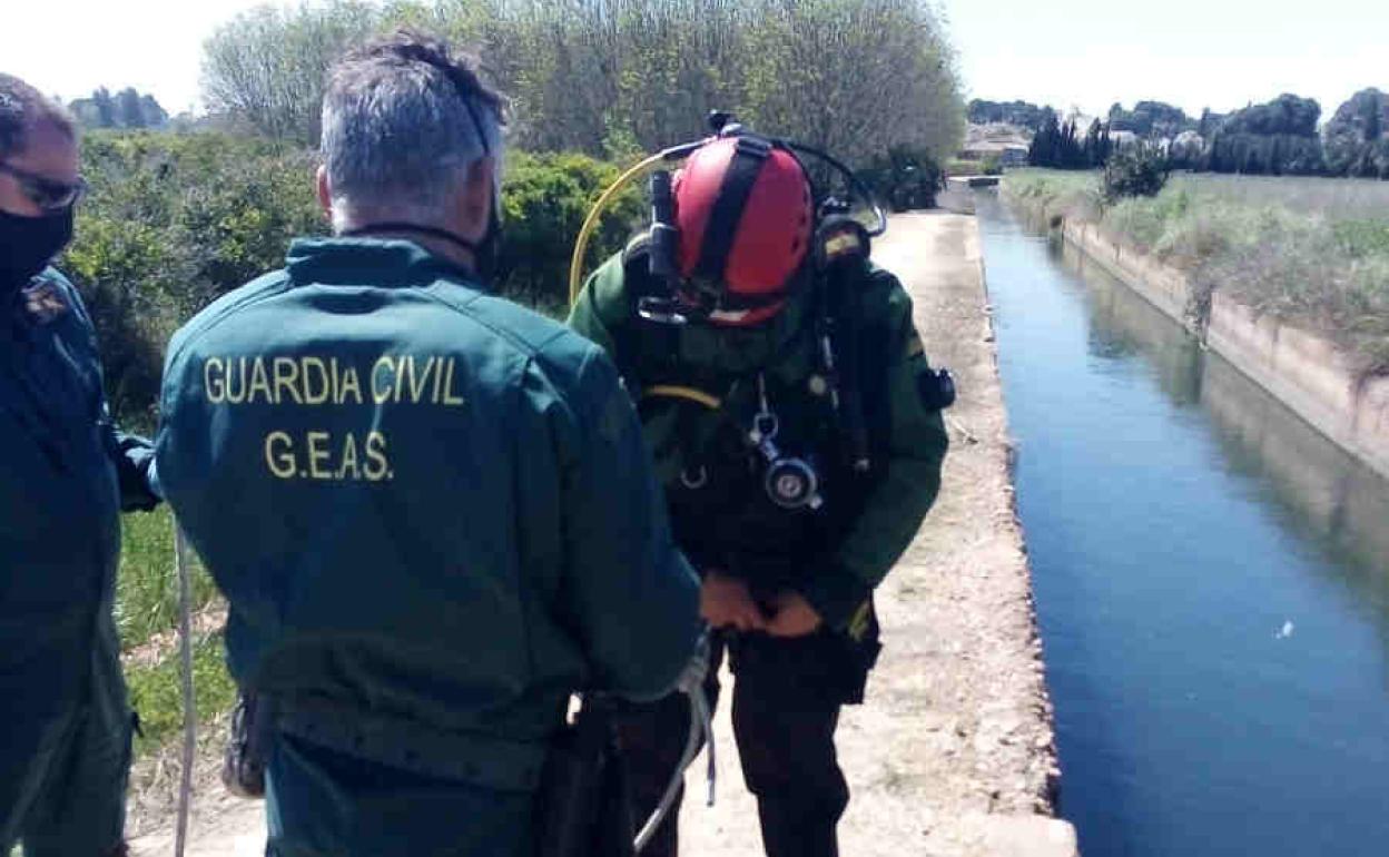 Dos buzos de la Guardia Civil junto a la acequia donde hallaron el cadáver. 