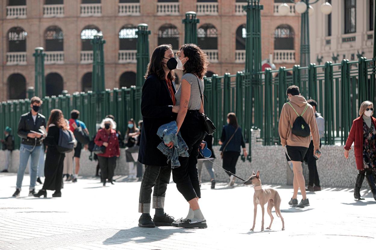 Una pareja se besa protegida por mascarillas en la Estación del Norte de Valencia. EFE