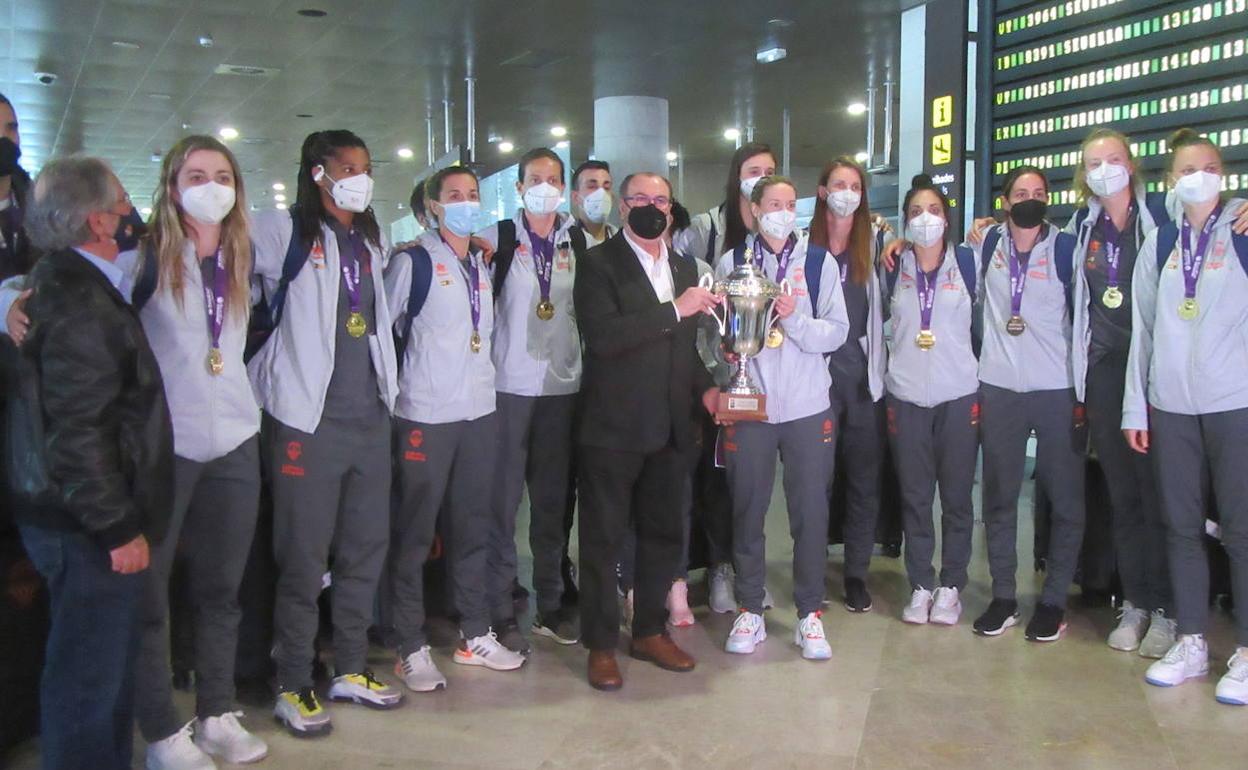 La expedición posa ayer junto al trofeo de la Eurocup Women, y el presidente Vicente Solá, a la llegada a la terminal de Manises . 