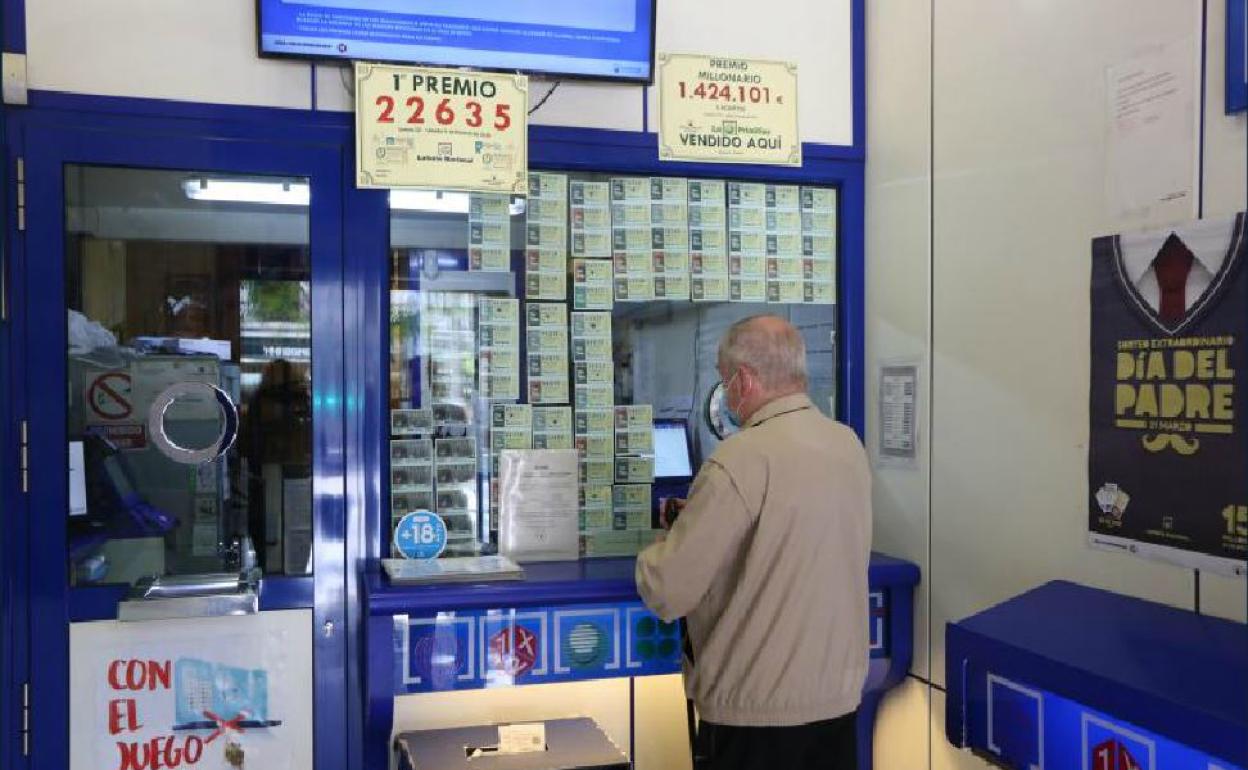 Un apostante valida sus boletos en una administración de Loterías. 