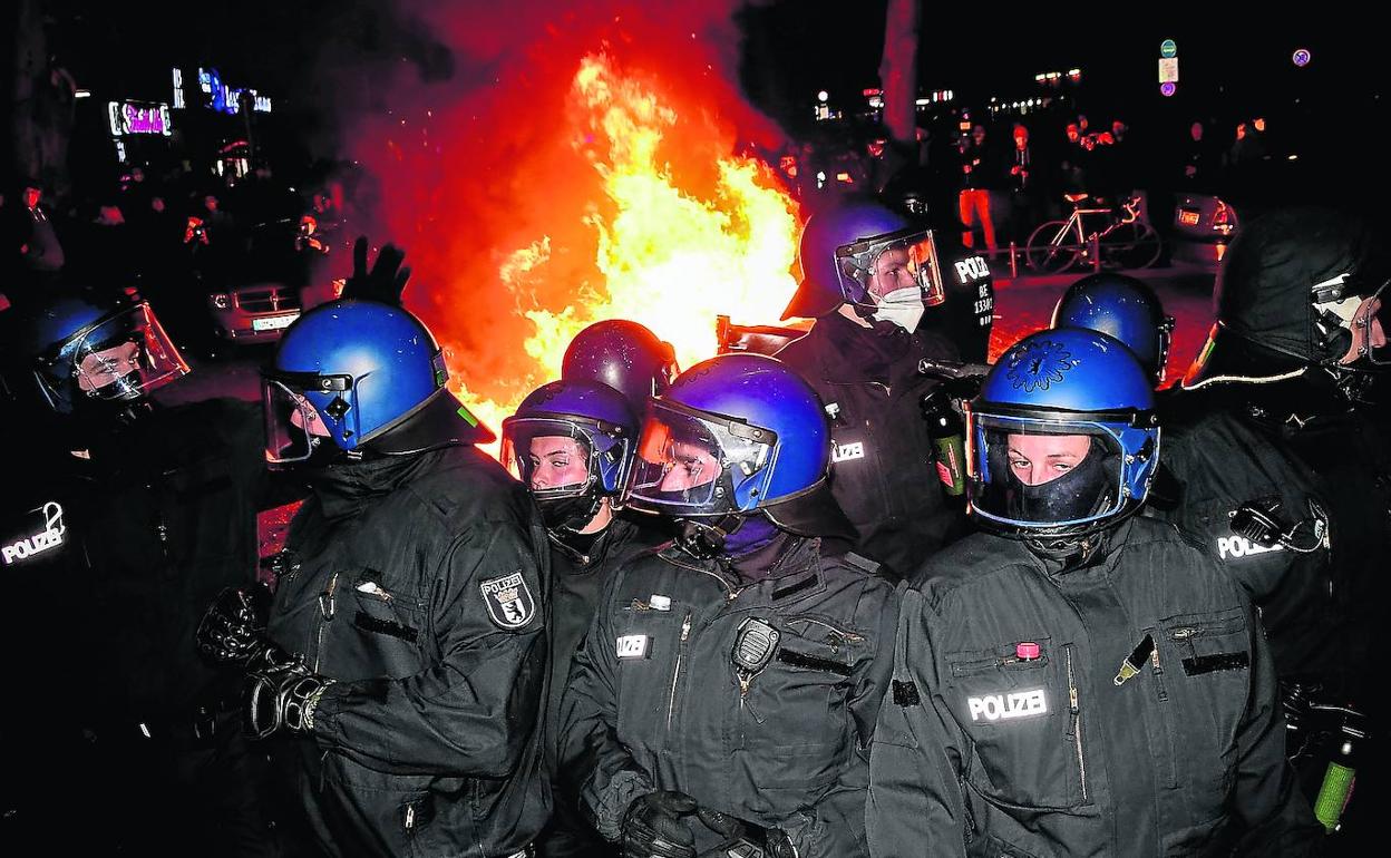 La Policía toma posiciones alrededor de una barricada incendiada en el centro de Berlín. 