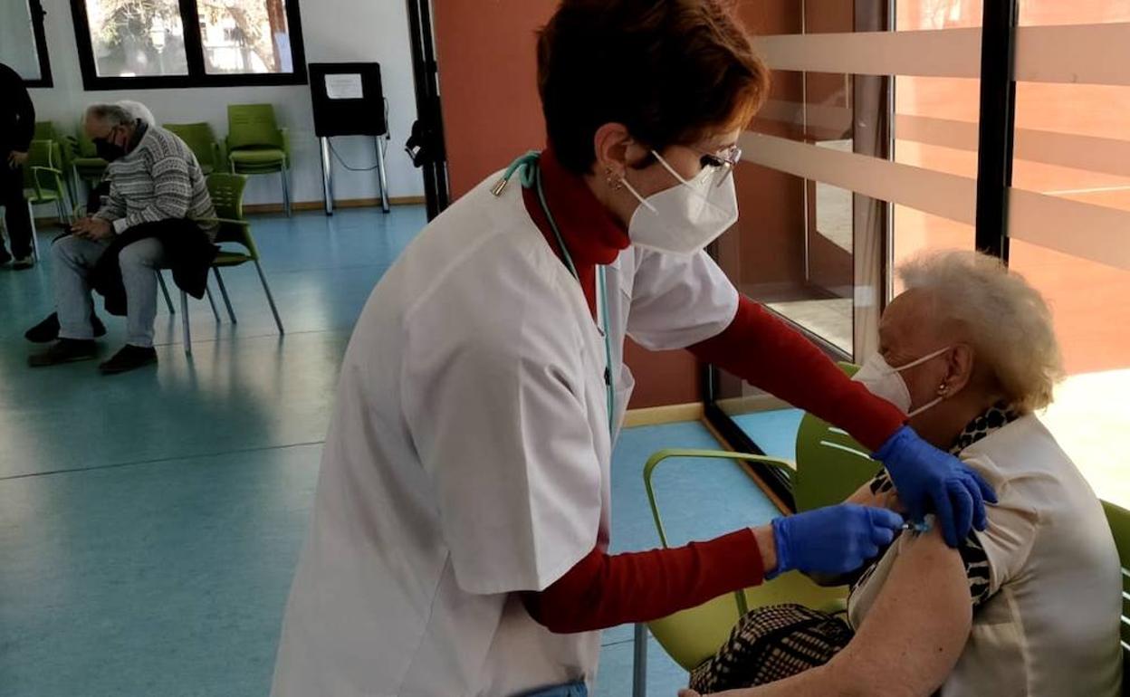 Una mujer recibe una dosis de una vacuna. 