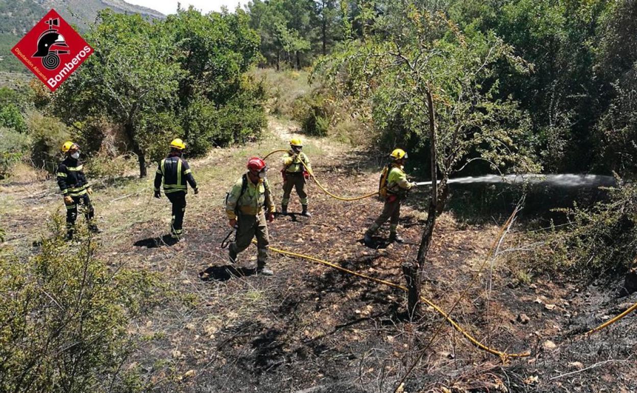 Los bomberos sofocan el fuego a pie en Finestrat. 