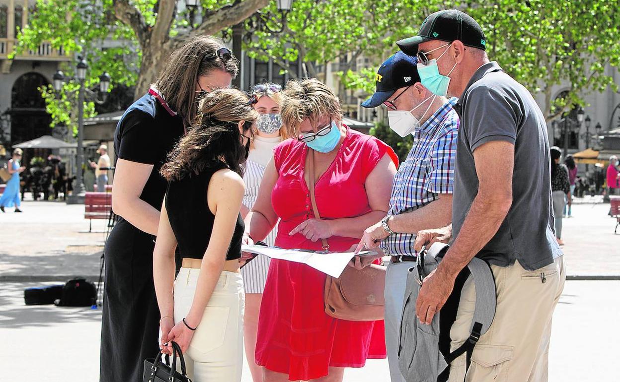 Un grupo de turistas en el centro de Valencia observa un mapa de la ciudad. 