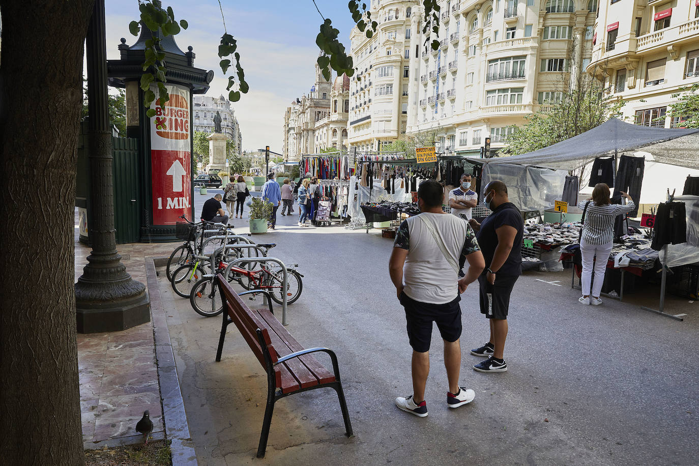 Protestas, mercadillos y restos de instalaciones se mezclan junto a la plaza del Ayuntamiento. Comerciantes y vecinos de la zona insisten en los problemas para acceder en coche mientras el monolito del 15M sigue protegido por vallas.