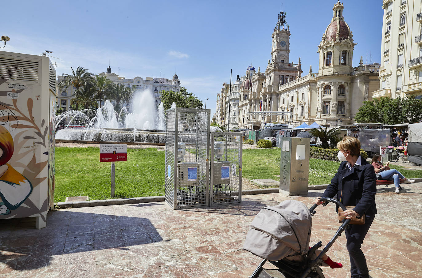 Protestas, mercadillos y restos de instalaciones se mezclan junto a la plaza del Ayuntamiento. Comerciantes y vecinos de la zona insisten en los problemas para acceder en coche mientras el monolito del 15M sigue protegido por vallas.