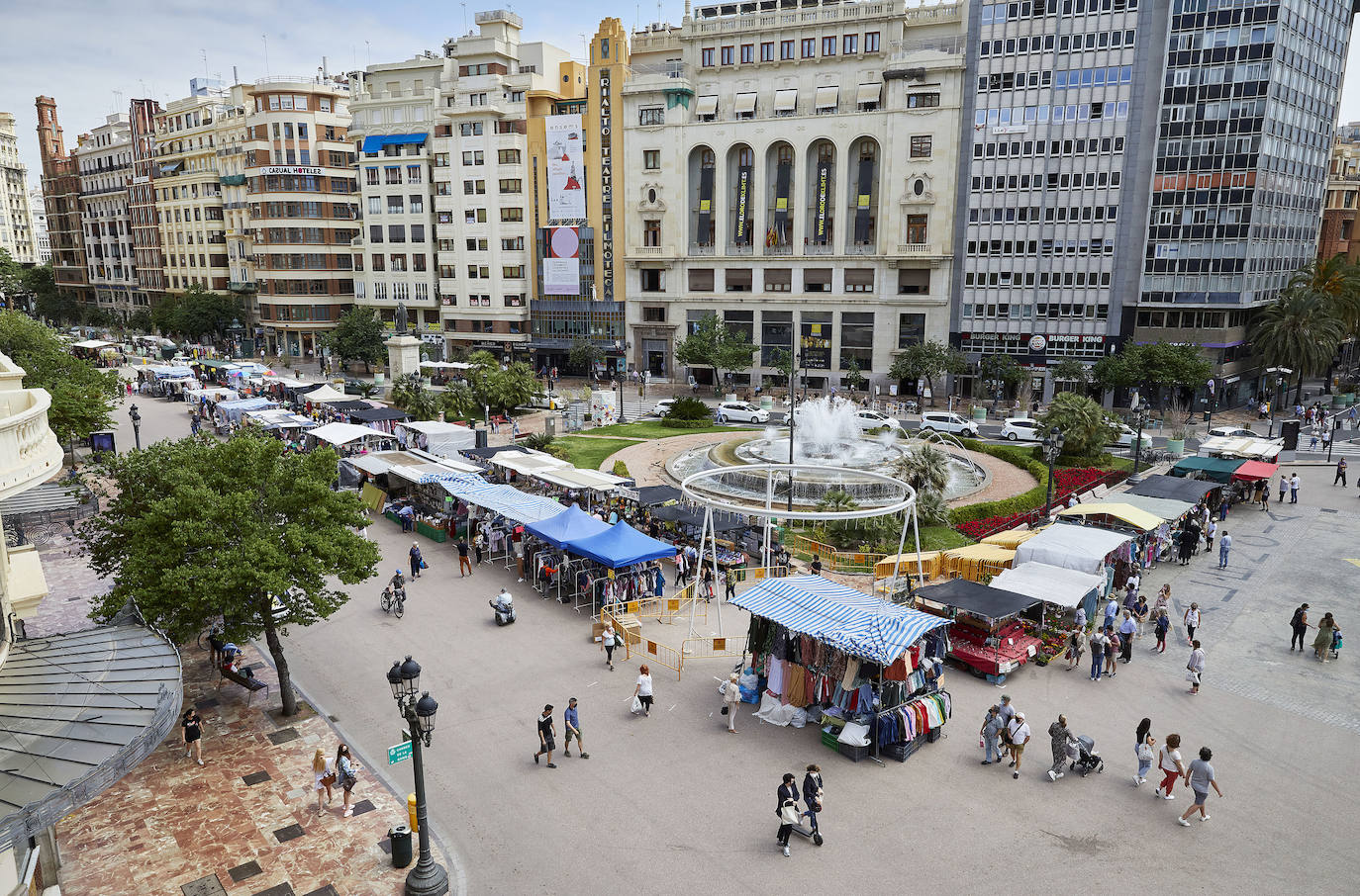 Protestas, mercadillos y restos de instalaciones se mezclan junto a la plaza del Ayuntamiento. Comerciantes y vecinos de la zona insisten en los problemas para acceder en coche mientras el monolito del 15M sigue protegido por vallas.