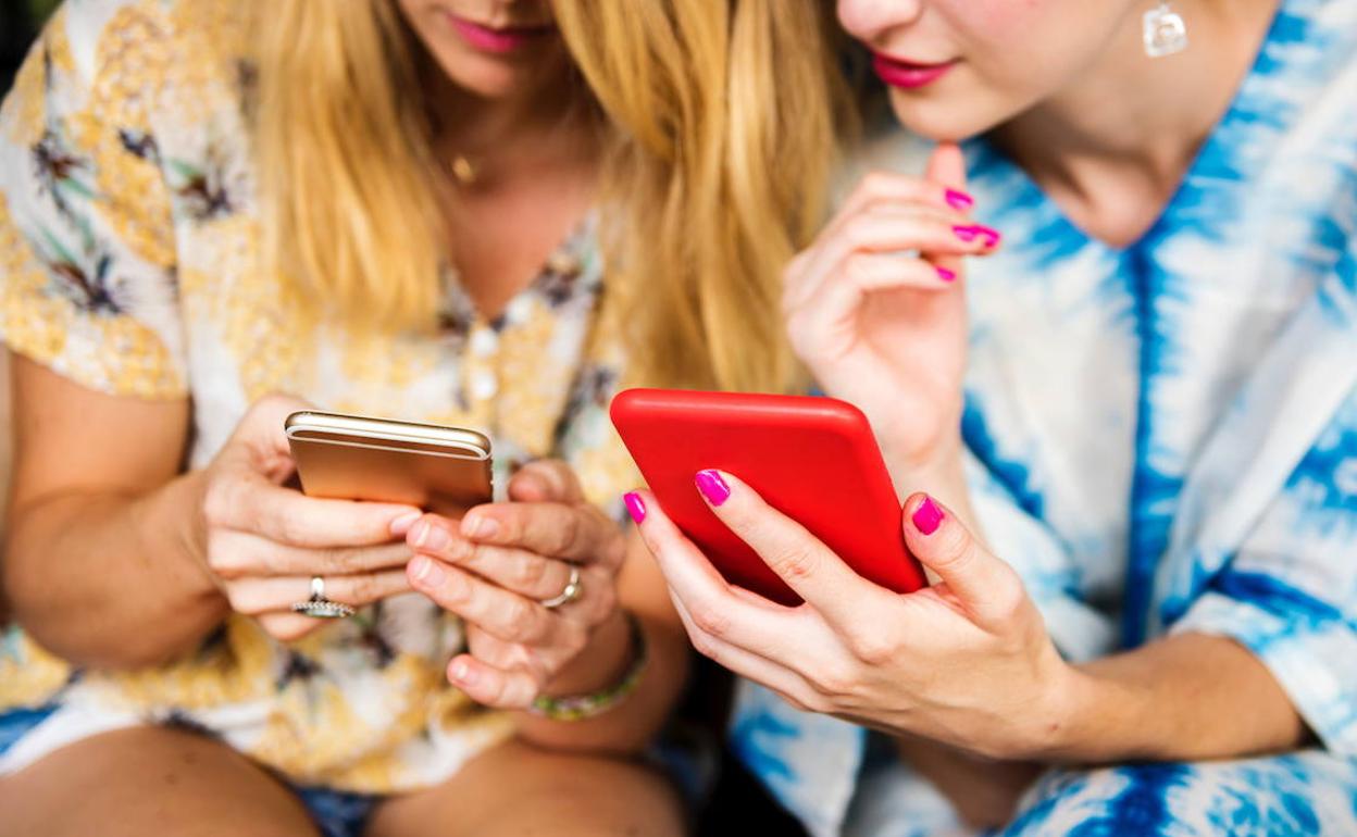 Dos jóvenes consultan sus teléfonos móviles, en una imagen de archivo